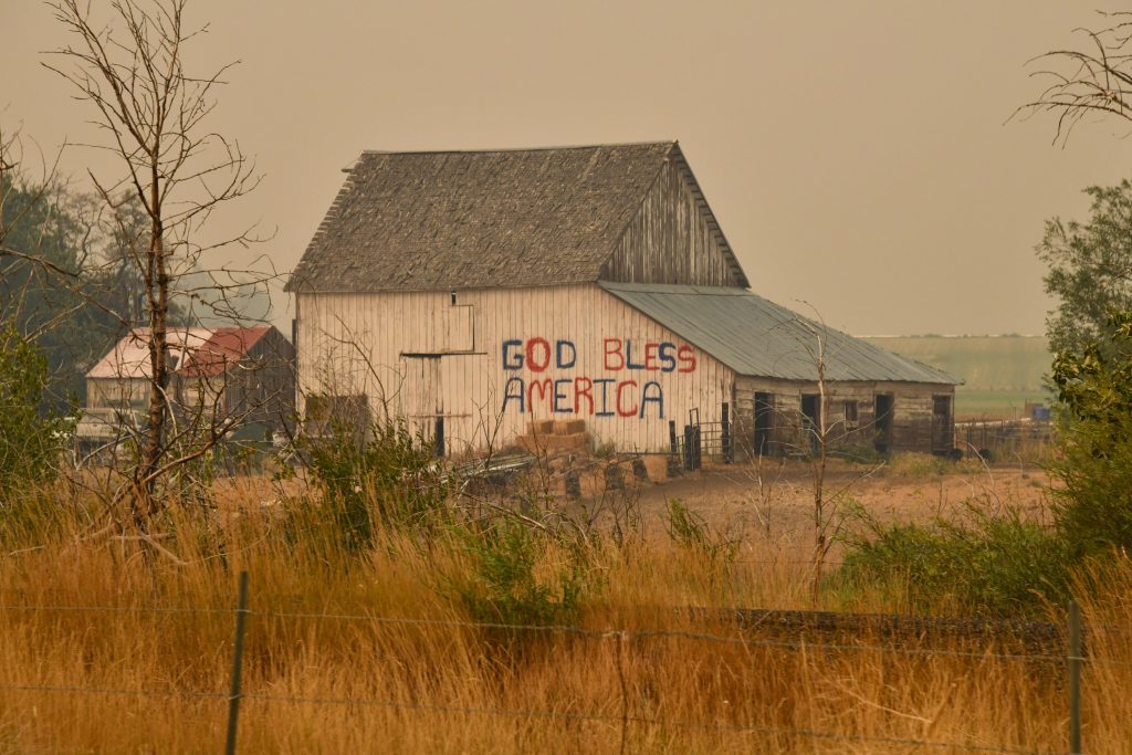 A barn with the words "God bless America" written on the side.