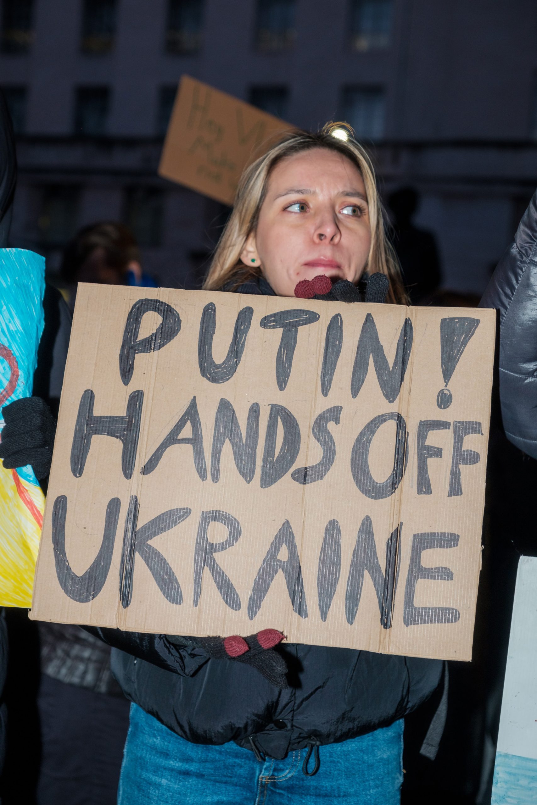 Woman protesting and holding a sign that says Putin! Hands off Ukraine. Image by Ehimetalor Akhere Unuabona.