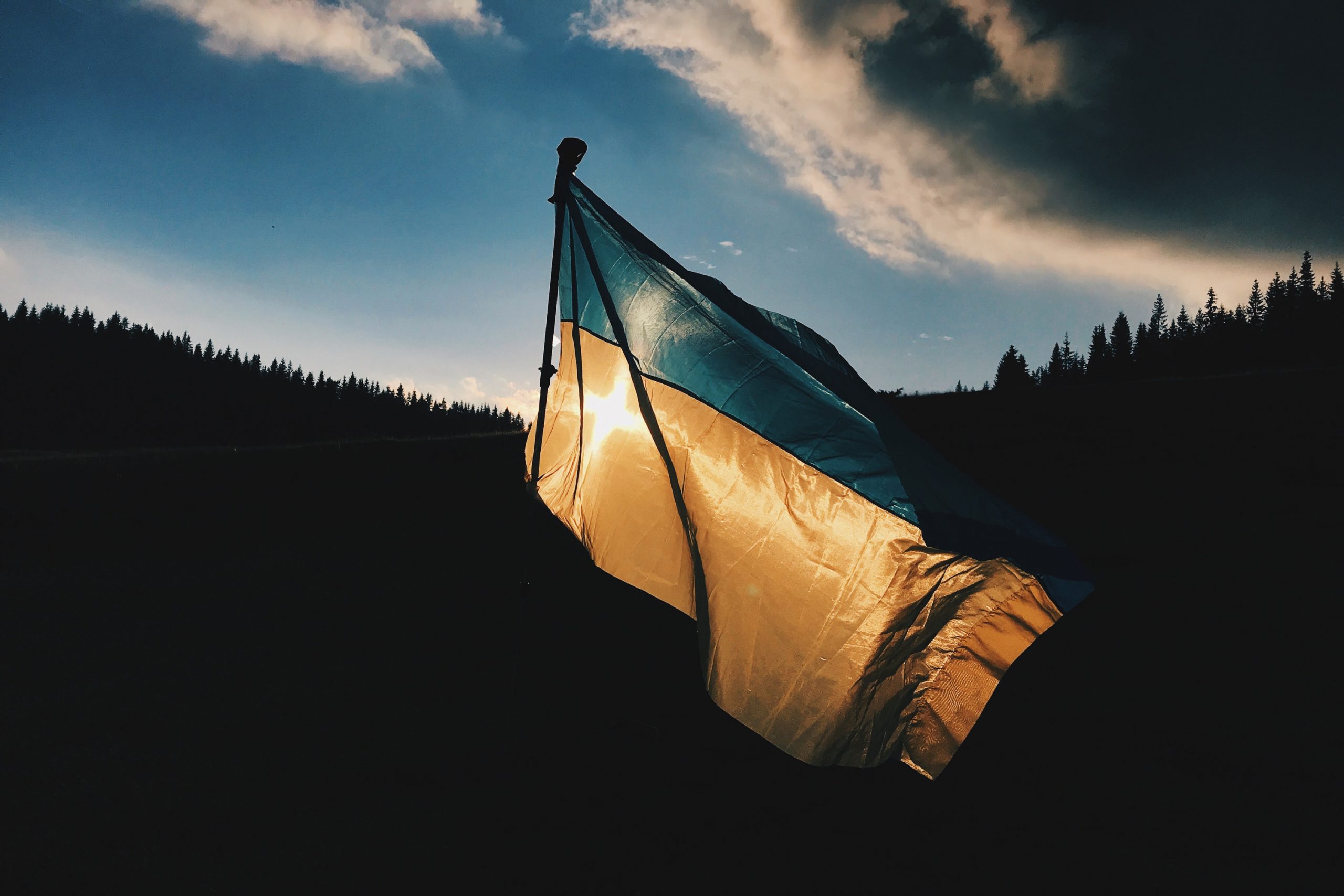 Ukrainian flag blowing in the wind at sunset.