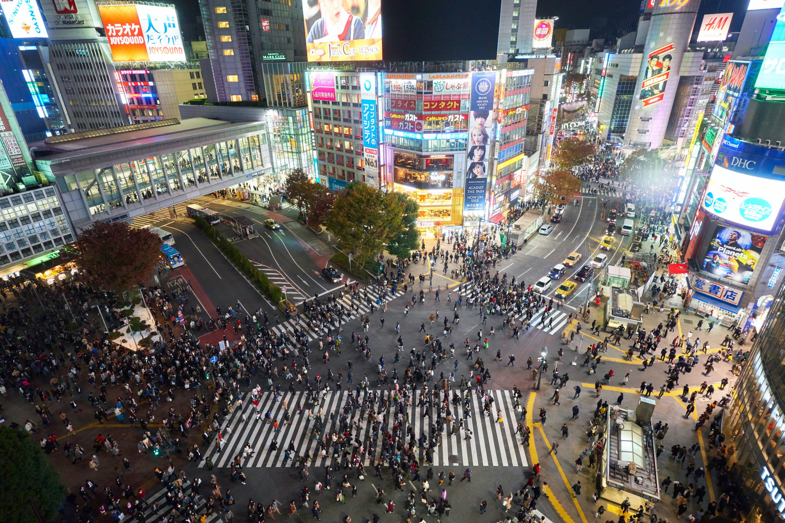 Arial photo of a busy intersection in Tokyo, Japan at night and artificially lit.